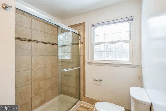 bathroom featuring an enclosed shower and toilet