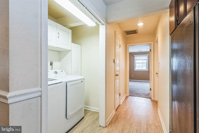 washroom featuring washing machine and dryer and cabinets