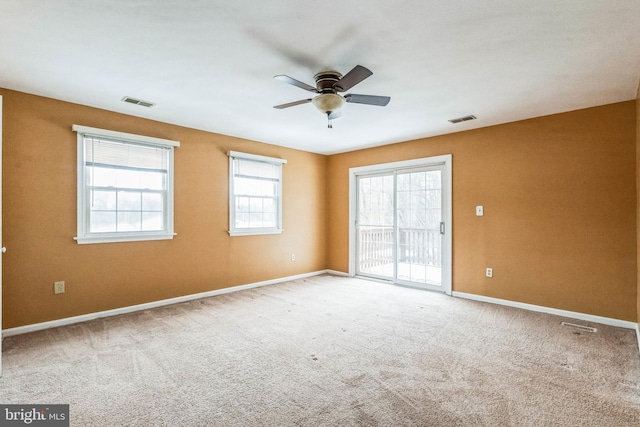 spare room featuring ceiling fan and light colored carpet