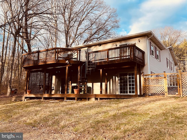 back of property featuring a wooden deck and a yard