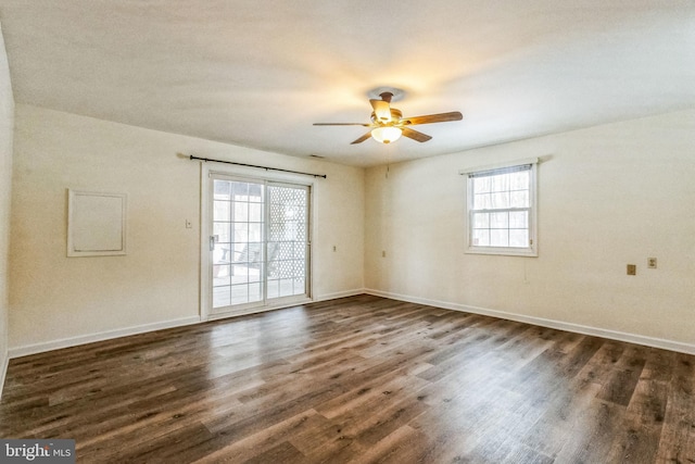 unfurnished room with ceiling fan, a wealth of natural light, and dark hardwood / wood-style flooring