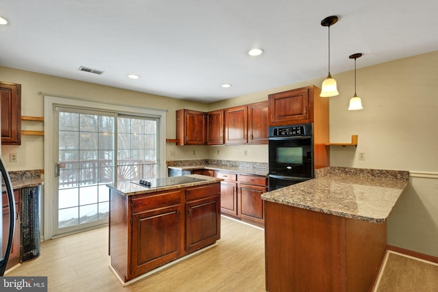 kitchen with light stone countertops, pendant lighting, kitchen peninsula, and black appliances