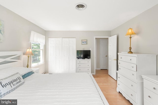 bedroom with a closet and light hardwood / wood-style floors