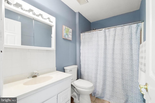 bathroom featuring backsplash, toilet, tile patterned floors, and vanity