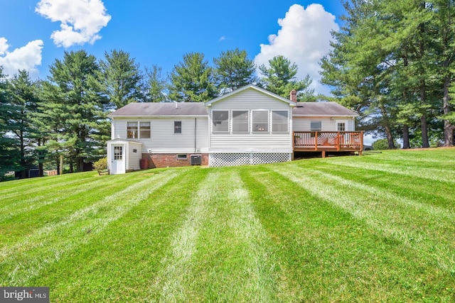 rear view of house featuring a wooden deck, central air condition unit, and a lawn