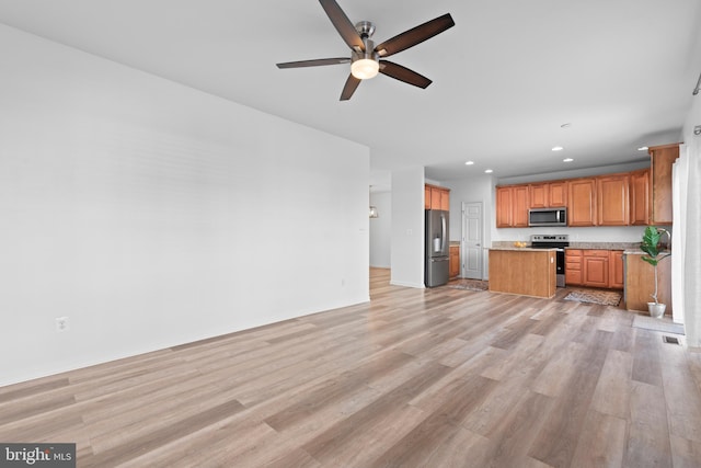 kitchen featuring a center island, light wood-type flooring, ceiling fan, and appliances with stainless steel finishes