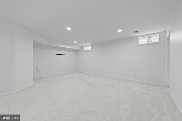 basement featuring light colored carpet and a wealth of natural light