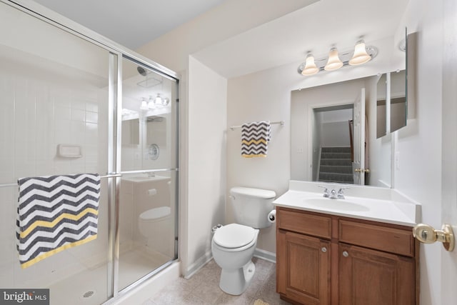 bathroom featuring vanity, a shower with shower door, and toilet