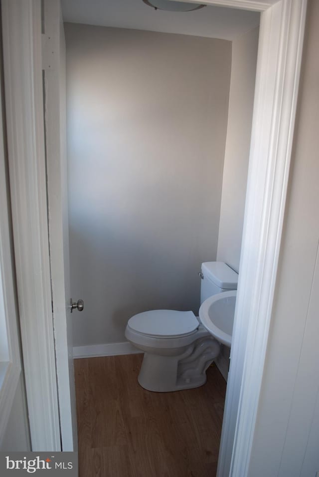 bathroom with hardwood / wood-style flooring and toilet