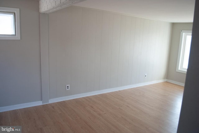 empty room featuring light hardwood / wood-style flooring and wood walls