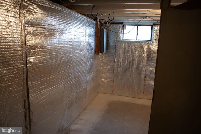 basement featuring electric panel and wood walls