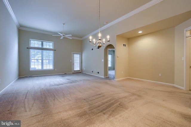 carpeted empty room with crown molding, a towering ceiling, and ceiling fan