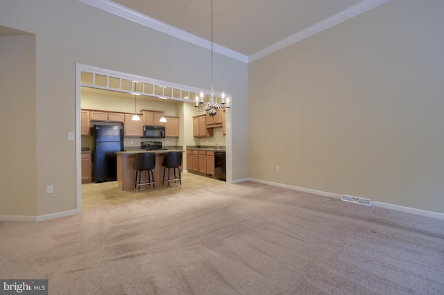 kitchen featuring a breakfast bar, hanging light fixtures, a center island, ornamental molding, and black appliances