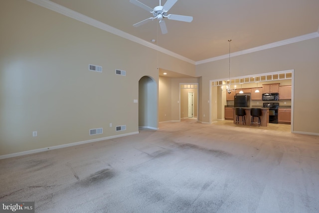 unfurnished living room with crown molding, light colored carpet, ceiling fan with notable chandelier, and a high ceiling