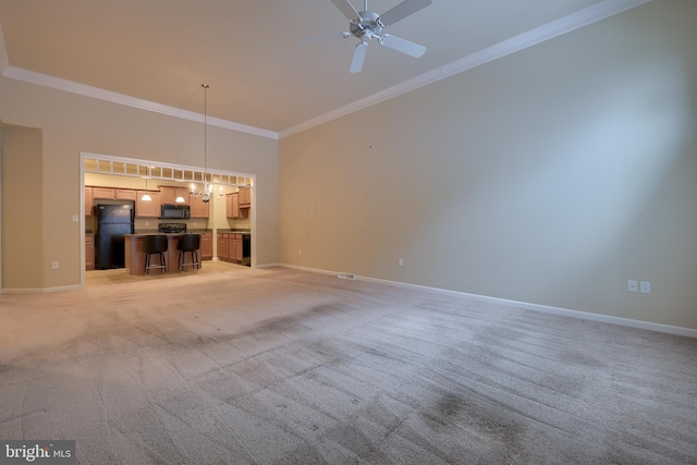 unfurnished living room with crown molding, a towering ceiling, light colored carpet, and ceiling fan