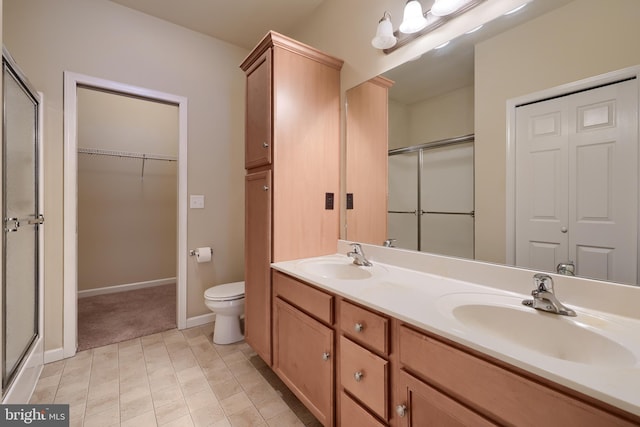 bathroom with vanity, toilet, and a shower with shower door