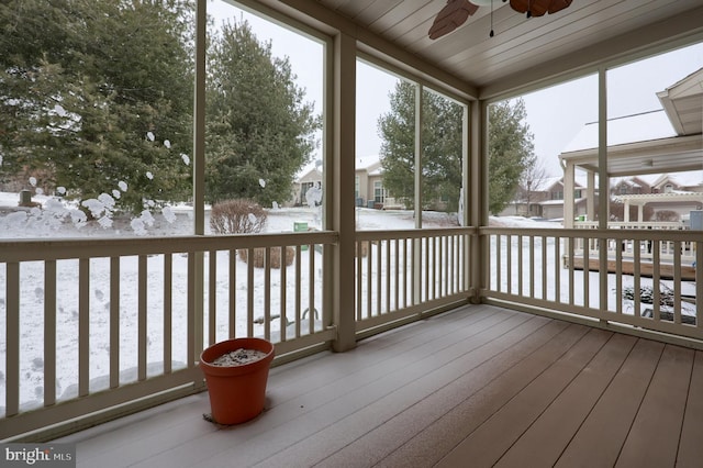 unfurnished sunroom featuring ceiling fan