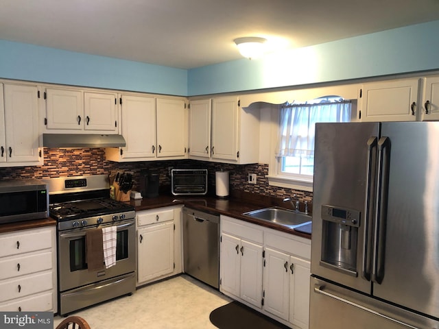 kitchen featuring tasteful backsplash, sink, white cabinets, and appliances with stainless steel finishes