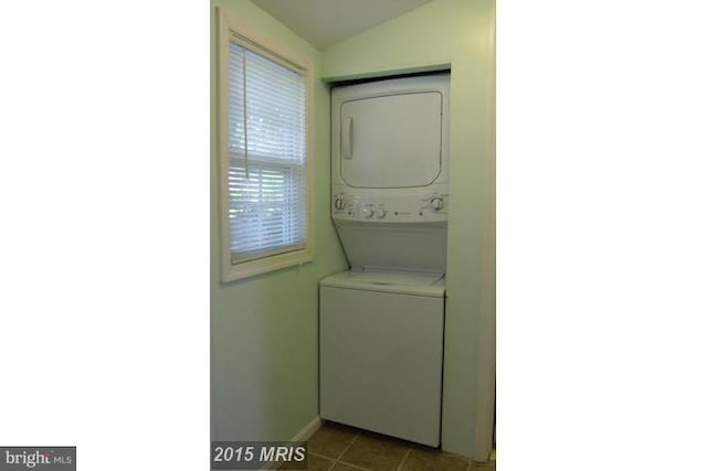 washroom with tile patterned floors and stacked washer and dryer