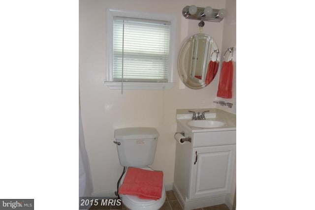 bathroom featuring tile patterned flooring, vanity, and toilet