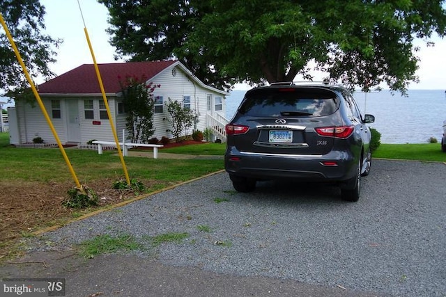 view of side of home with a lawn and a water view