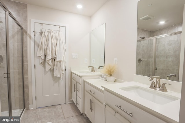 bathroom featuring tile patterned flooring, vanity, and a shower with door