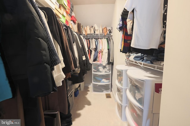 walk in closet featuring independent washer and dryer and carpet flooring