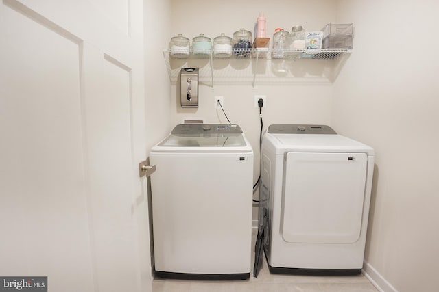 clothes washing area with separate washer and dryer and light tile patterned floors