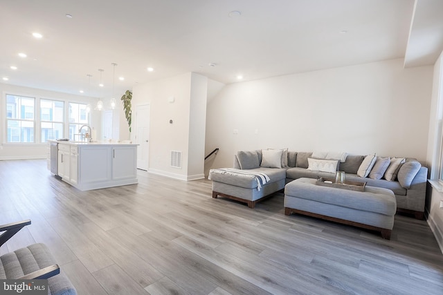 living room featuring sink and light wood-type flooring