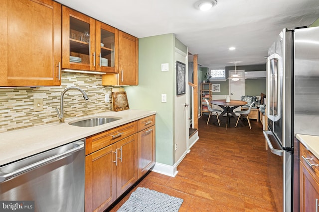 kitchen with stainless steel appliances, backsplash, wood-type flooring, hanging light fixtures, and sink