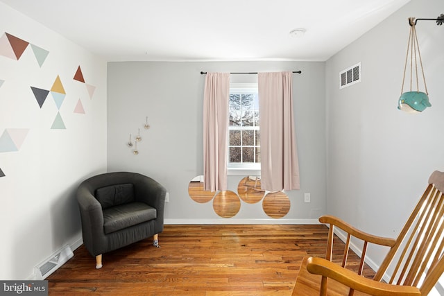 sitting room with wood-type flooring