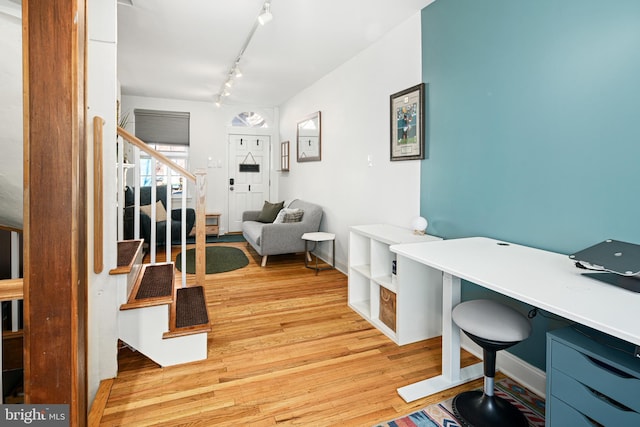 office with rail lighting and light hardwood / wood-style floors