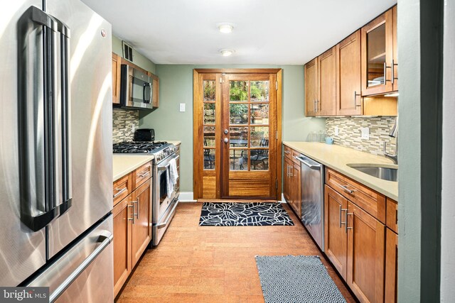 kitchen with appliances with stainless steel finishes, decorative backsplash, and sink