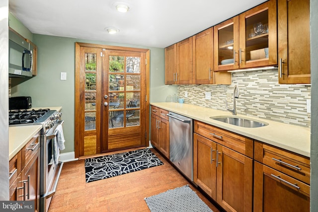 kitchen with decorative backsplash, appliances with stainless steel finishes, and sink