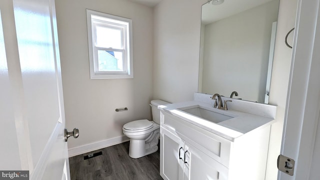 bathroom with wood-type flooring, vanity, and toilet