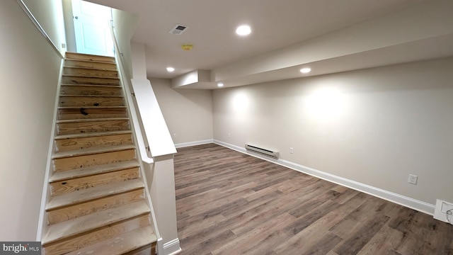 basement featuring hardwood / wood-style flooring and a baseboard heating unit