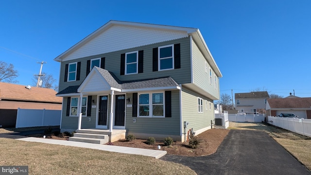 view of front property featuring a front lawn and central AC