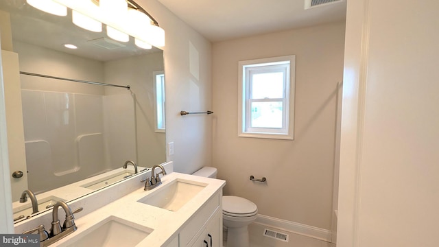 bathroom featuring a shower, vanity, and toilet