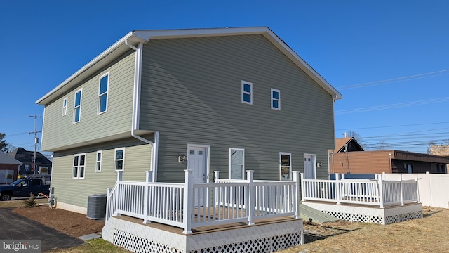 back of house featuring cooling unit and a wooden deck