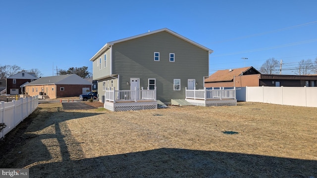 rear view of house with a lawn and a deck