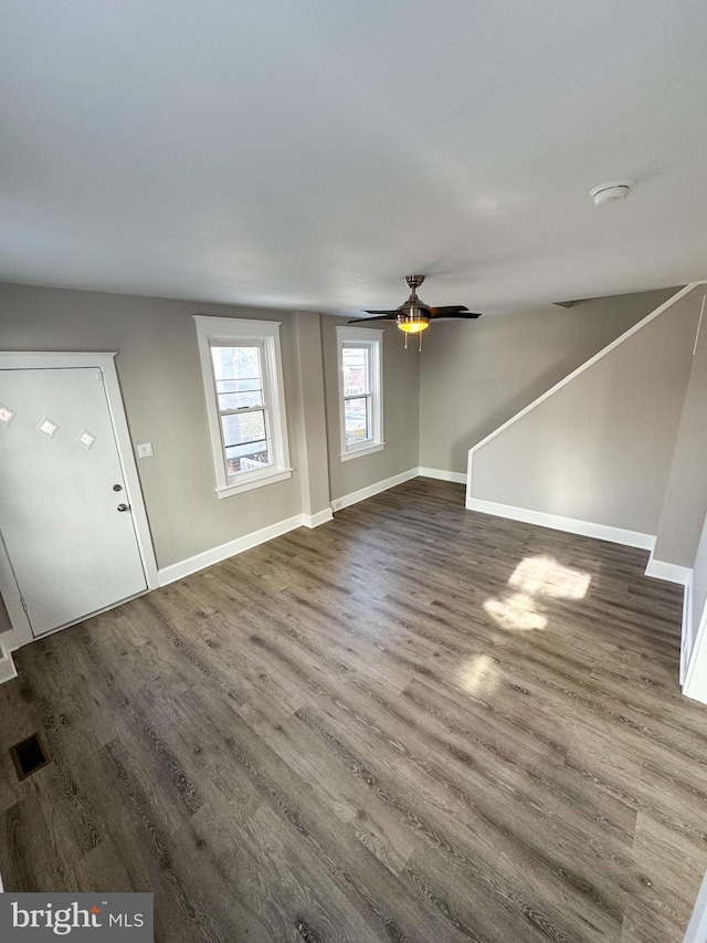 unfurnished living room with ceiling fan and dark hardwood / wood-style floors