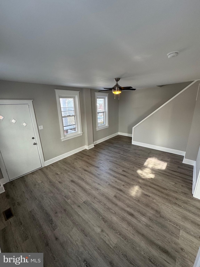 unfurnished living room with ceiling fan and dark hardwood / wood-style floors