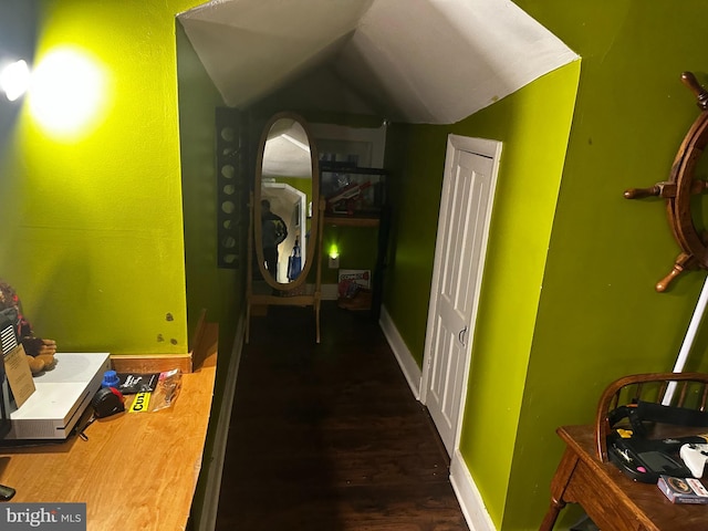 corridor with dark hardwood / wood-style flooring and vaulted ceiling