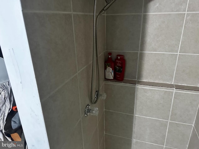 interior details featuring tiled shower