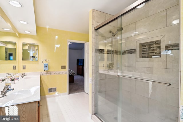 bathroom with a shower with shower door and vanity