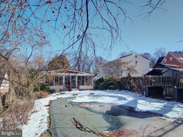 snow covered pool featuring a sunroom