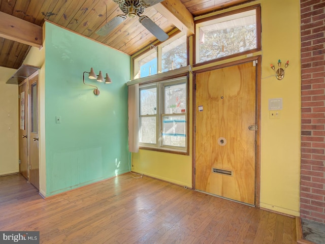 entrance foyer featuring wood-type flooring, wooden ceiling, a healthy amount of sunlight, and vaulted ceiling with beams