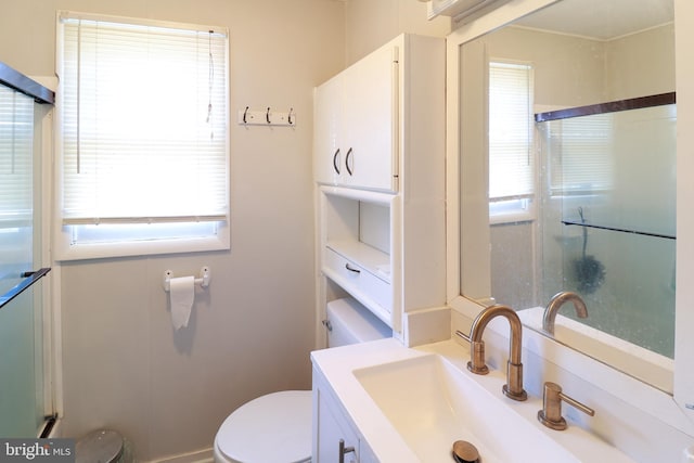 bathroom featuring vanity, plenty of natural light, and toilet