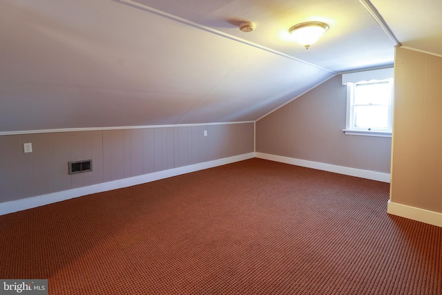 additional living space with vaulted ceiling and carpet flooring