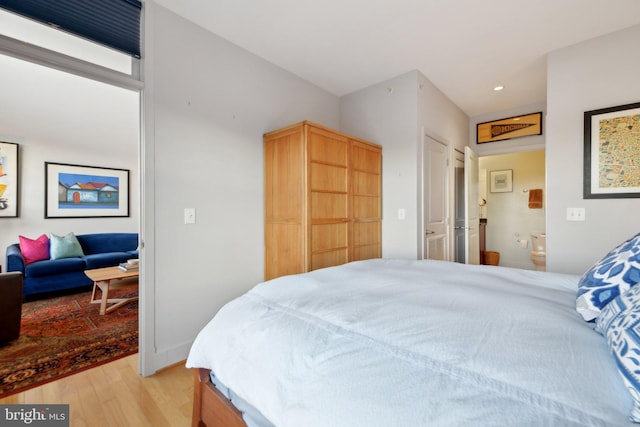 bedroom featuring light hardwood / wood-style floors and connected bathroom